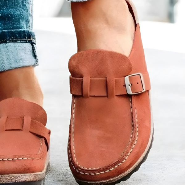 Brown loafers with a buckle on a light background