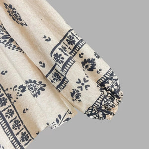 Beige fabric with black floral patterns on a gray background