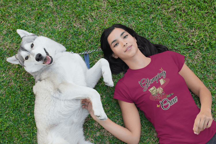 Woman lying on grass with a white dog