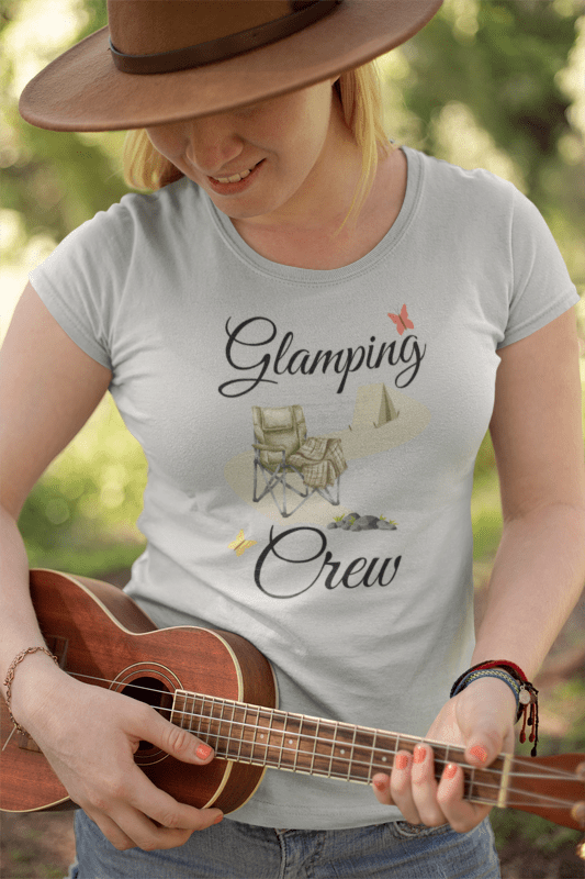 Person wearing a 'Glamping Crew' t-shirt and playing a ukulele outdoors.