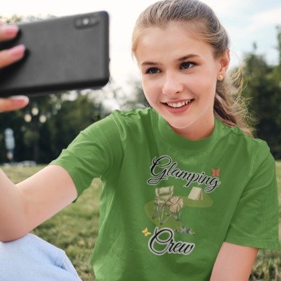 Person wearing a green t-shirt with 'Glamping Crew' design, taking a selfie outdoors.