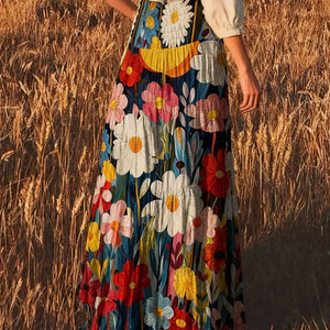 Person wearing a colorful floral dress standing in a field.