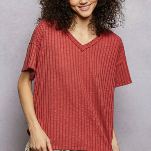 Woman wearing a red textured shirt against a gray background