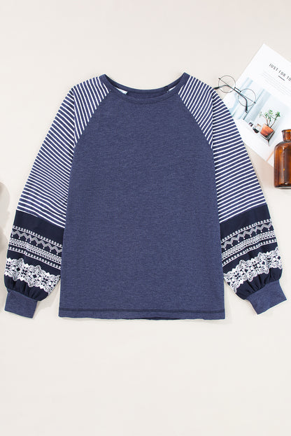 Blue sweatshirt with striped sleeves on a white background