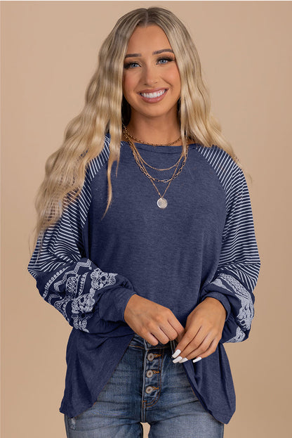 Woman wearing a blue long-sleeve top with lace details on a beige background