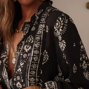 Black and white patterned blouse with a blurred background