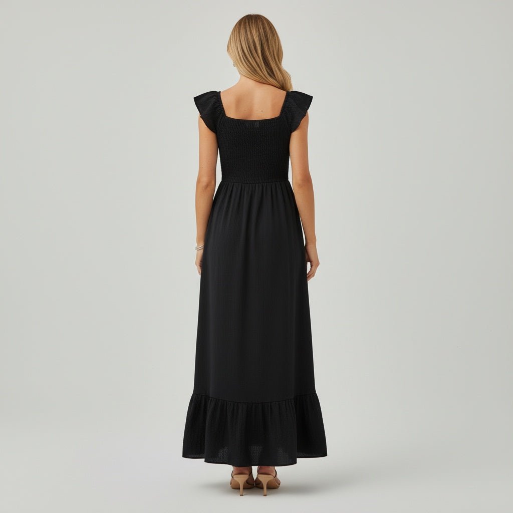 Woman wearing a black dress with cap sleeves on a gray background