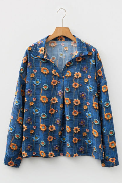 Blue floral-patterned jacket on a wooden hanger against a white background