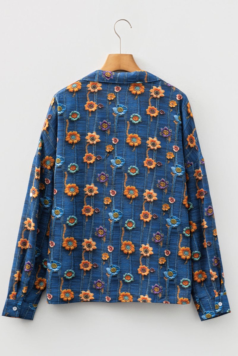 Blue floral patterned shirt on a hanger against a white background