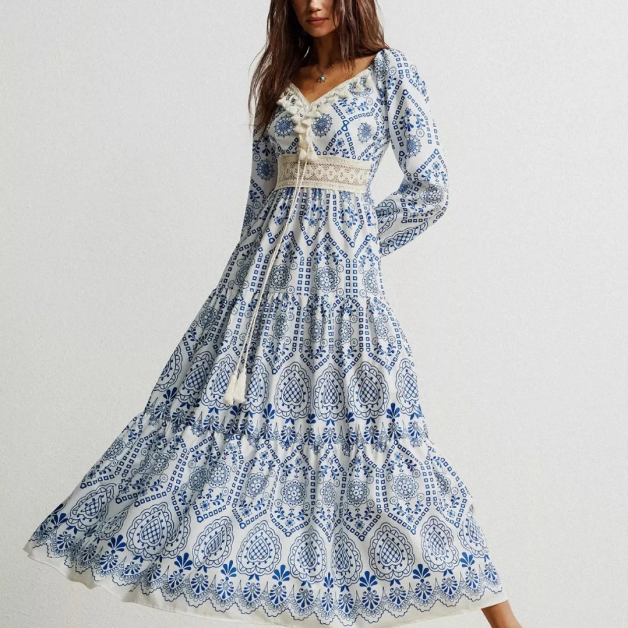 Woman wearing a blue and white patterned dress on a plain background