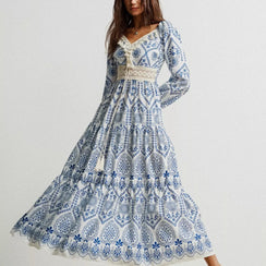 Woman wearing a blue and white patterned dress on a plain background