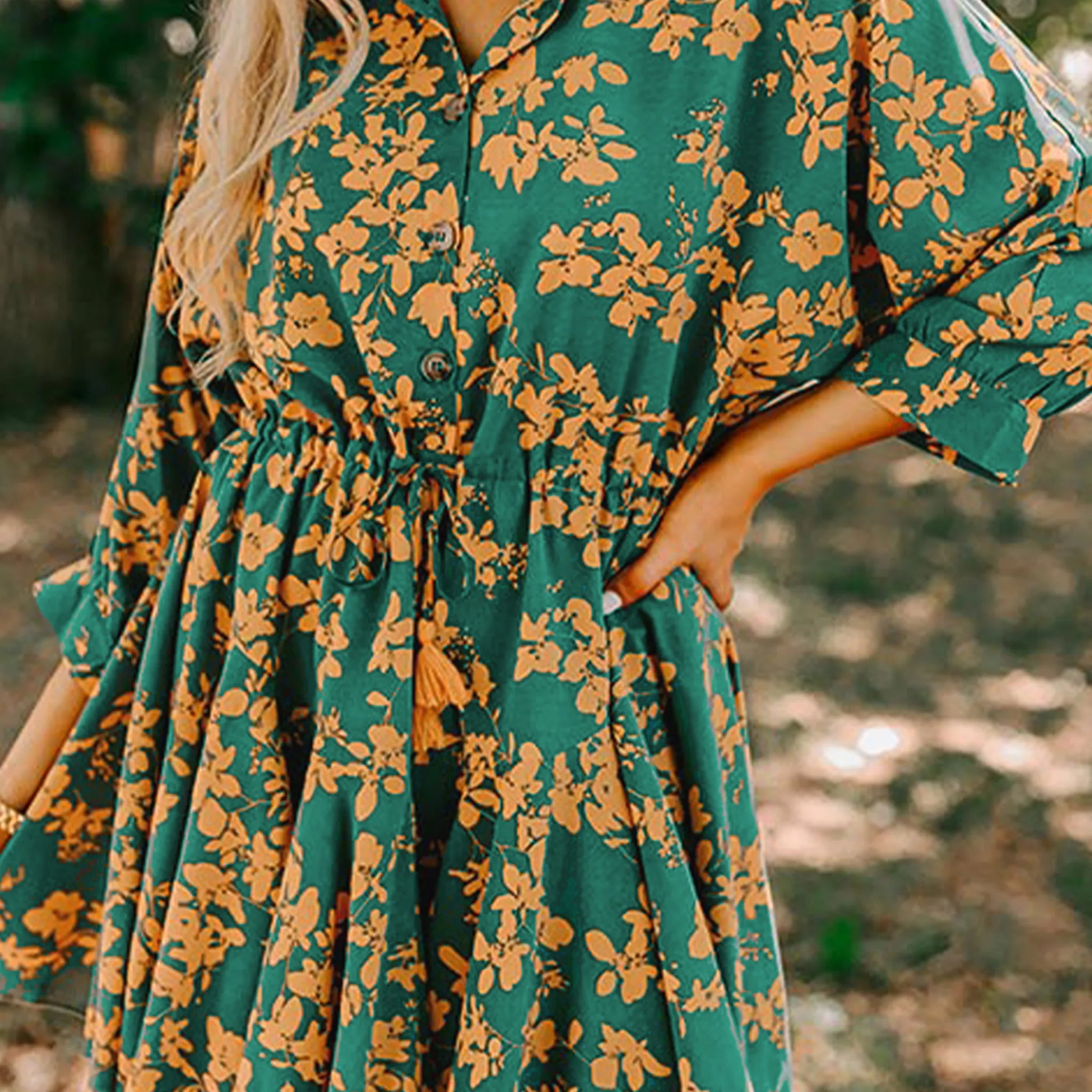 Green floral dress with long sleeves worn by a person outdoors.