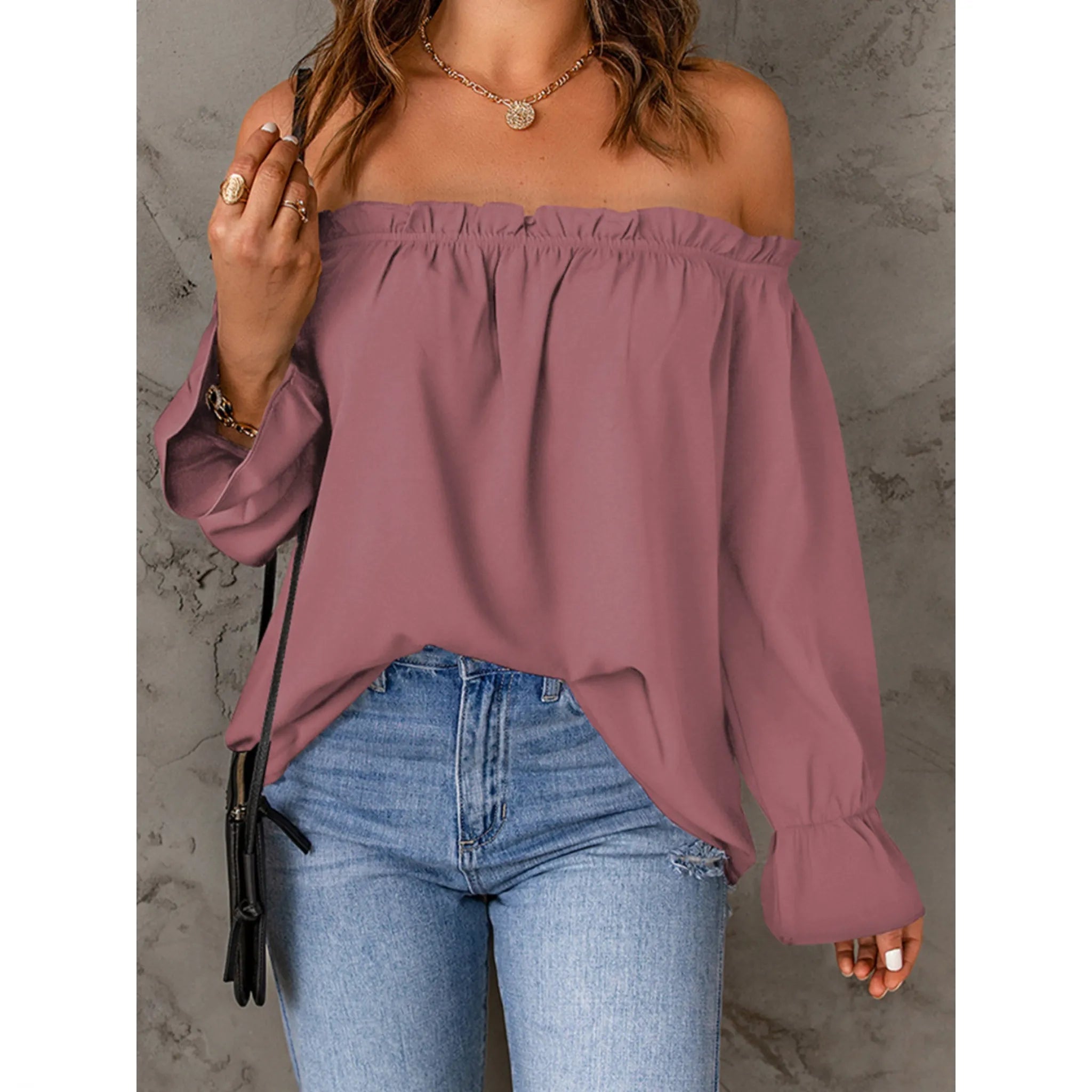 Purple off-shoulder top worn by a person against a gray background
