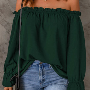Green off-shoulder top worn by a person against a gray background