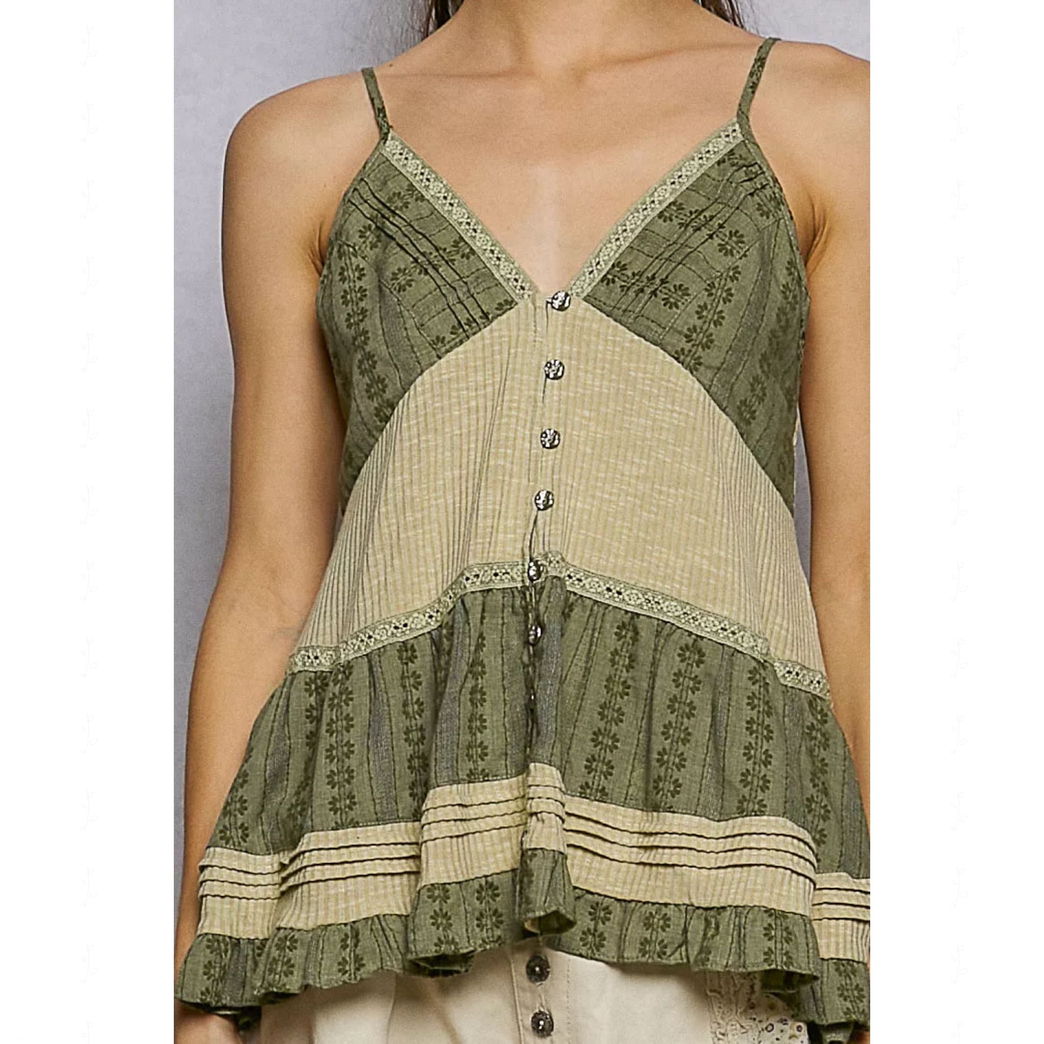 Green and beige patterned sleeveless top worn by a person on a plain background