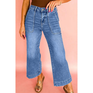 Person wearing blue jeans on a pink background